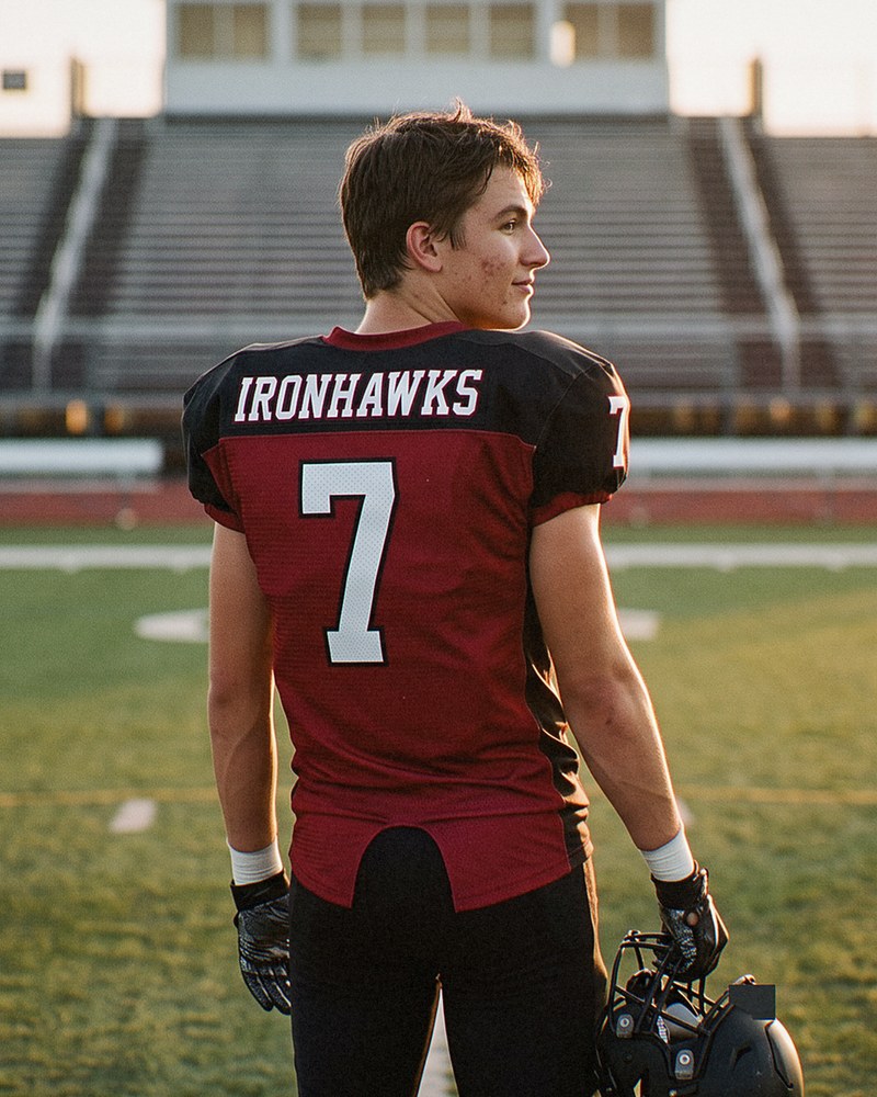 High school football player in a custom sublimated jersey at sunset